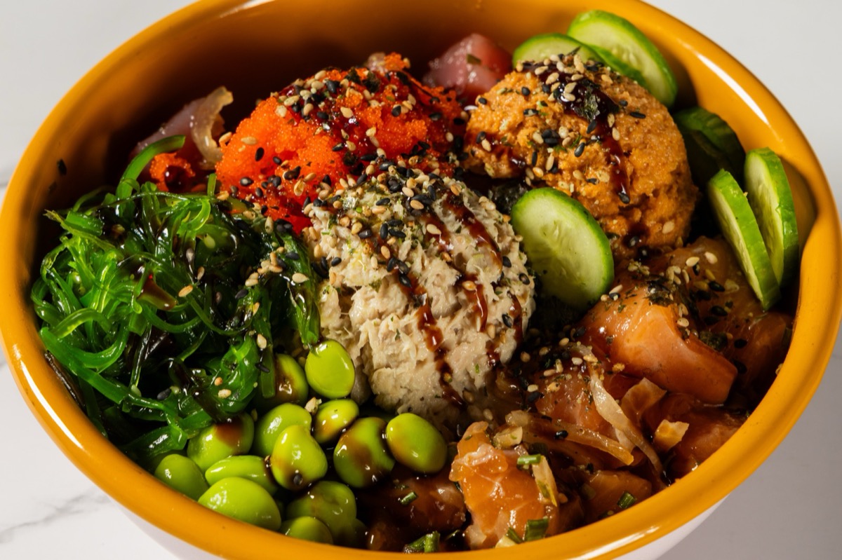 OniGuru signature poke bowl with cubed salmon and ahi tuna, seaweed salad, edamame, cucumber, tobiko and sesame
